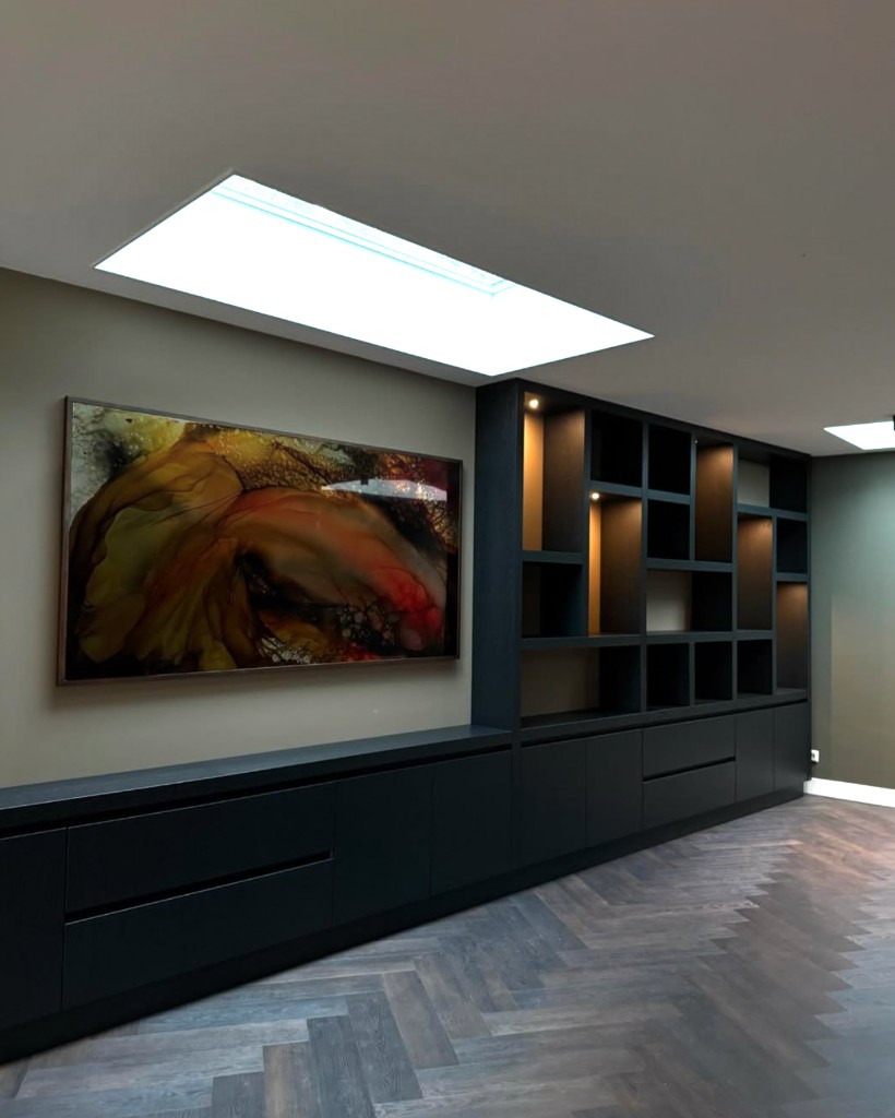Maatwerk tv-wandmeubel in zwart eiken met open vakken en spotverlichting